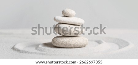 Stack of spa stones on light sand. Zen concept
