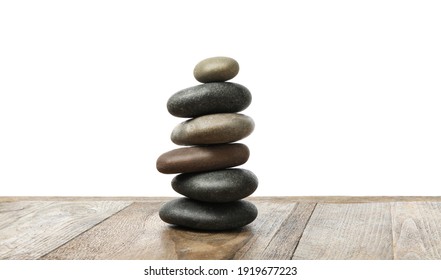 Stack of spa stones on wooden table against white background