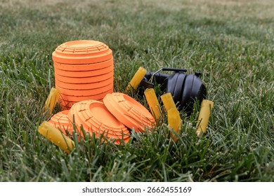 Stack of sporting clay targets surrounded by empty shotgun shells