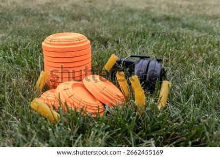Stack of sporting clay targets surrounded by empty shotgun shells