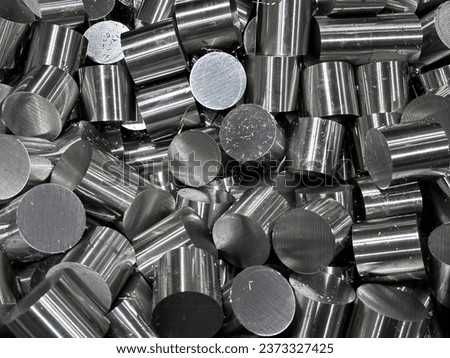 Stack of stainless steel rods in a container box.Steel bar cutting. The raw material for manufacturing by CNC milling machine.