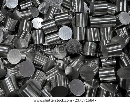 Stack of stainless steel rods in a container box.Steel bar cutting. The raw material for manufacturing by CNC milling machine.