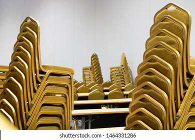 Stack Steel Chair Fabric Seat Pad Yellow Gold Color And Table Arrange In Row Ready To Set Up For Big Meeting, Conference, Business, Workshop, Gala Dinner, Wedding Ceremony In Convention Hall Of Hotel