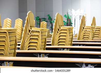 Stack Steel Chair Fabric Seat Pad Yellow Gold Color And Table Arrange In Row Ready To Set Up For Big Meeting, Conference, Business, Workshop, Gala Dinner, Wedding Ceremony In Convention Hall Of Hotel