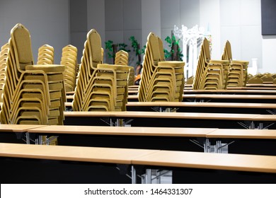 Stack Steel Chair Fabric Seat Pad Yellow Gold Color And Table Arrange In Row Ready To Set Up For Big Meeting, Conference, Business, Workshop, Gala Dinner, Wedding Ceremony In Convention Hall Of Hotel