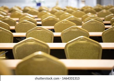 Stack Steel Chair Fabric Seat Pad Yellow Gold Color And Table Arrange In Row Ready To Set Up For Big Meeting, Conference, Business, Workshop, Gala Dinner, Wedding Ceremony In Convention Hall Of Hotel