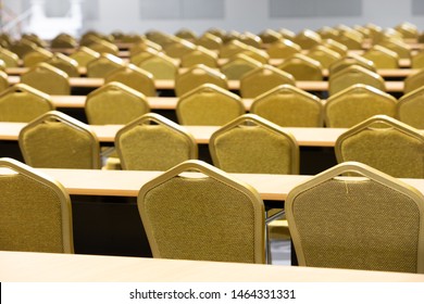 Stack Steel Chair Fabric Seat Pad Yellow Gold Color And Table Arrange In Row Ready To Set Up For Big Meeting, Conference, Business, Workshop, Gala Dinner, Wedding Ceremony In Convention Hall Of Hotel