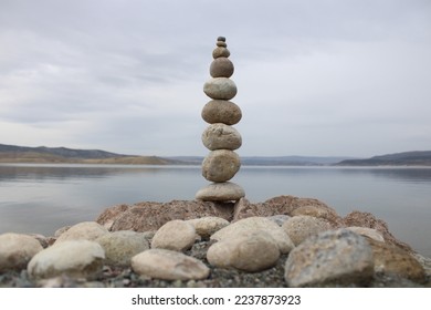 stack of stones on the beach. Various stones top view on the beach. Stone Tower, Land Art, Installation, Stones. stones in balance. Mindfulness themed photo.