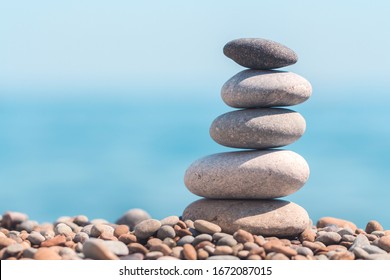 Stack stones on the coast of the sea in the nature. Cairn on the ocean beach, five pebbles tower. Concept of balance and harmony. Calm and spirit
