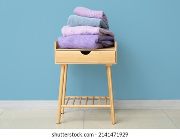Stack of sweaters on table near color wall in room