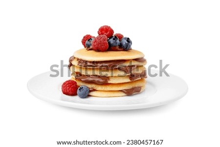 Stack of tasty pancakes with chocolate spread and berries isolated on white