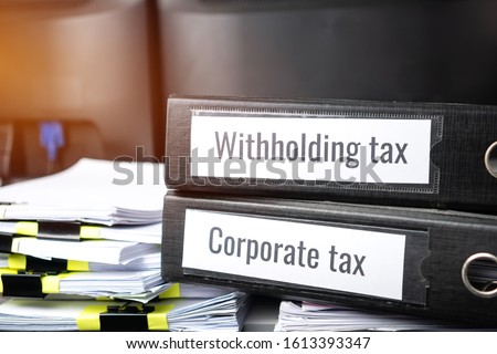 Stack of taxes binders report concept: Document of Withholding tax and corporate tax for accountant. withholding tax sometimes applies to royalties, rent or even sale duty must be paid to government