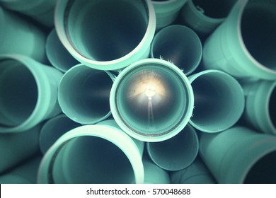 Stack of teal utility pipes at construction site