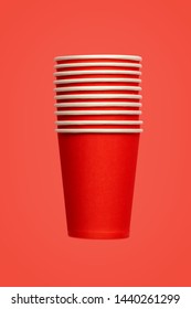 Stack Of Ten Red Paper Eco-friendly Cups On Red Background. Empty Space. Environmental Problems Concept. Simplicity Background.