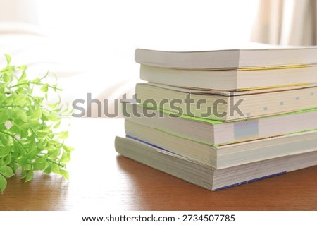 Stack of textbooks and reference books on desk for study and reading