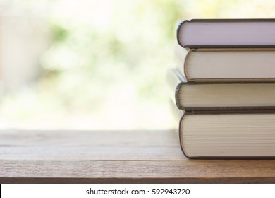 Stack Of Thick Books With Green Light And Bokeh Background