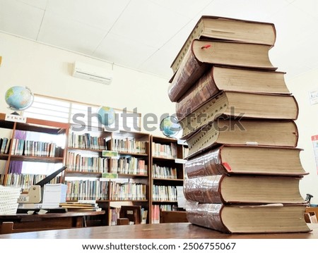 stack of thick books on the library table