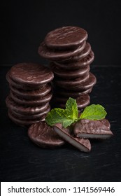 Stack Of Thin Chocolate Mint Candy With One Broken In Half To Show Creamy Center.