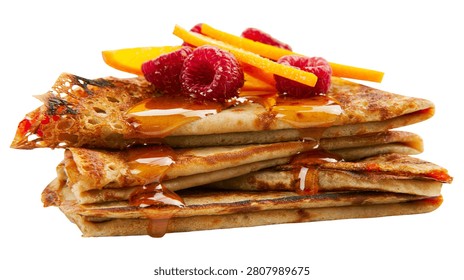 Stack of thin crepes topped with fresh raspberries and orange slices with syrup