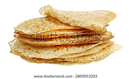 Stack of thin golden brown crepes with lacy edges