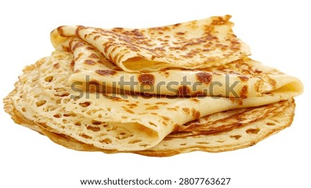 Stack of thin golden brown crepes with lacy edges and toasted spots