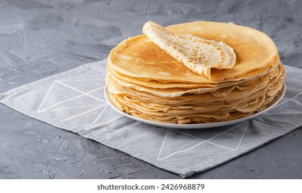 A stack of thin pancakes on a grey table , with copy space for text - Powered by Shutterstock