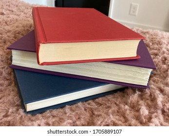 A stack of three books.