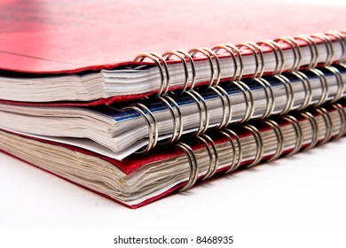 A Stack Of Three Lesson Plan Books With Metal Coil Binding.