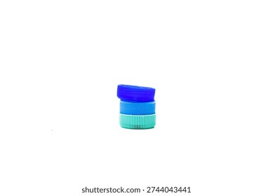 Stack of Three Multicolored Plastic Bottle Caps on White Background.