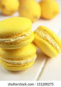 Stack Of Three Yellow Lemon Macaron With Lemon In Background