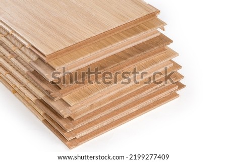 Stack of the three-layer engineered wood flooring boards with white oak face layer, pine core layer and glue-less locking joint system, fragment of butt-end parts close-up 

