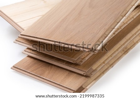 Stack of the three-layer engineered wood flooring boards with white oak face layer, pine core layer and glue-less locking joint system, fragment close-up 
