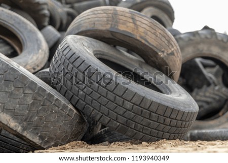 A stack of tires on an old garbage dump. Old worn out tires piled up. Season of the autumn.