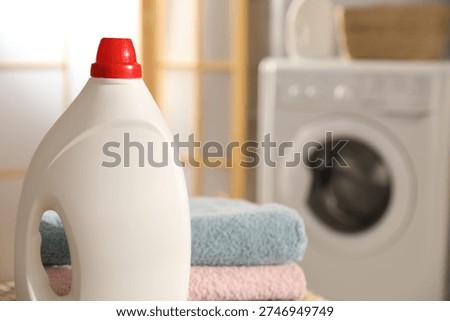 Stack of towels and detergent in bathroom, closeup. Space for text