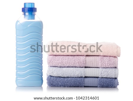 A stack of towels softener conditioner liquid laundry detergent on white background isolation