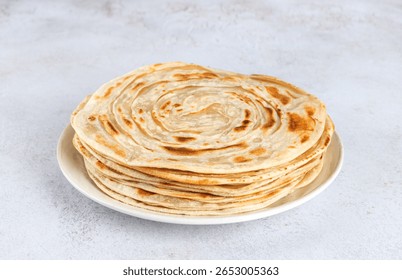 Stack of traditional Indian paratha flatbreads on white background. Indian food.
