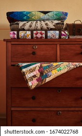 Stack Of Traditional Quilts On Chest Of Drawers