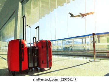 Stack Of Traveling Luggage In Airport Terminal And Passenger Plane Flying Over Sky