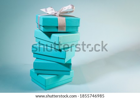 Stack of turquoise blue boxes, one tied with white silk ribbon. Suitable for concepts like luxury gift, anniversary, Valentine's day, Mother's day or christmas