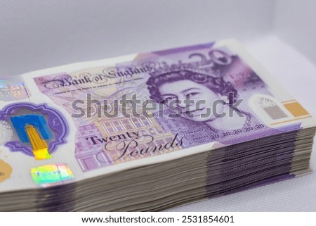 A stack of twenty-pound banknotes from the Bank of England, featuring a portrait of Queen Elizabeth II.