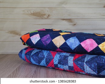 Stack Of Two Patchwork Quilts In Various Colors