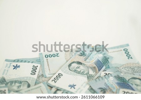 A stack of two thousand rupiah banknotes with negative space, Indonesian money. suitable for background, finance, banking, cash, savings.