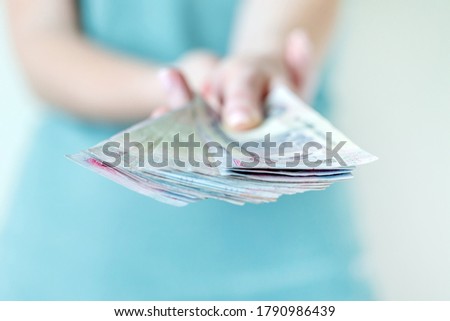 Stack of UAE dirhams in hands. Bills of five hundred dirhams.