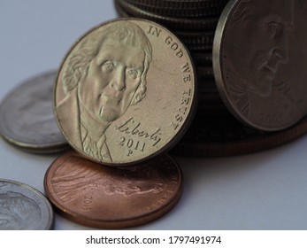 A stack of US Dollar coins in different sizes, colors and shapes 