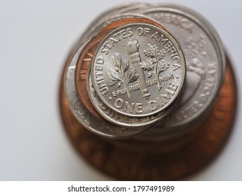 A stack of US Dollar coins in different sizes, colors and shapes 