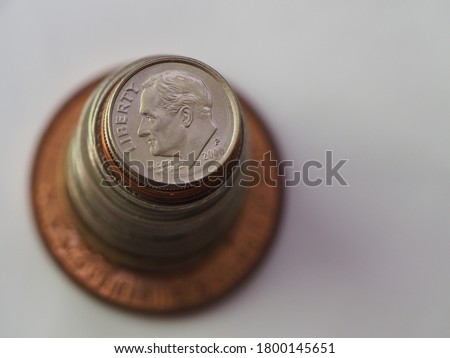A stack of US Dollar coins in different sizes, colors and shapes