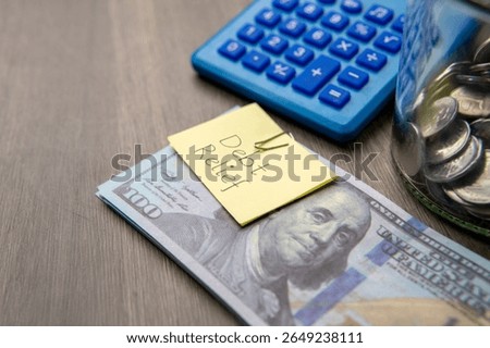 A stack of US hundred-dollar bills with a "DEBT RELIEF" note. Financial solutions, managing debt concept.