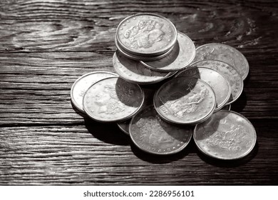 Stack of US old west dollar silver coins on wooden deck.