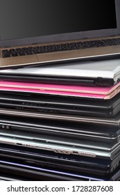 Stack of used laptops in different colors and models. Tha notebooks for repair and service.