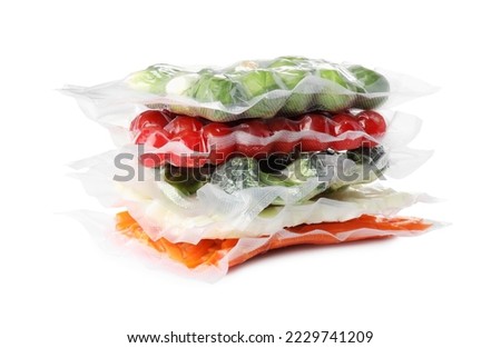 Stack of vacuum packs with different food products on white background
